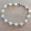 PULSERA DE ACERO DOS BOLITAS 3 MM INTERCALADAS CON BOLITAS SÍMIL PIEDRA MULTICOLOR PASTEL. LARGO 18 CM.