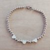 PULSERA DE ACERO DE BOLITAS 3 MM CON TRES CORAZONES PULIDOS EN EL CENTRO. LARGO 18 CM.