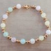 PULSERA DE ACERO DORADO DOS BOLITAS 3 MM INTERCALADAS CON BOLITAS SÍMIL PIEDRA MULTICOLOR PASTEL. LARGO 18 CM.