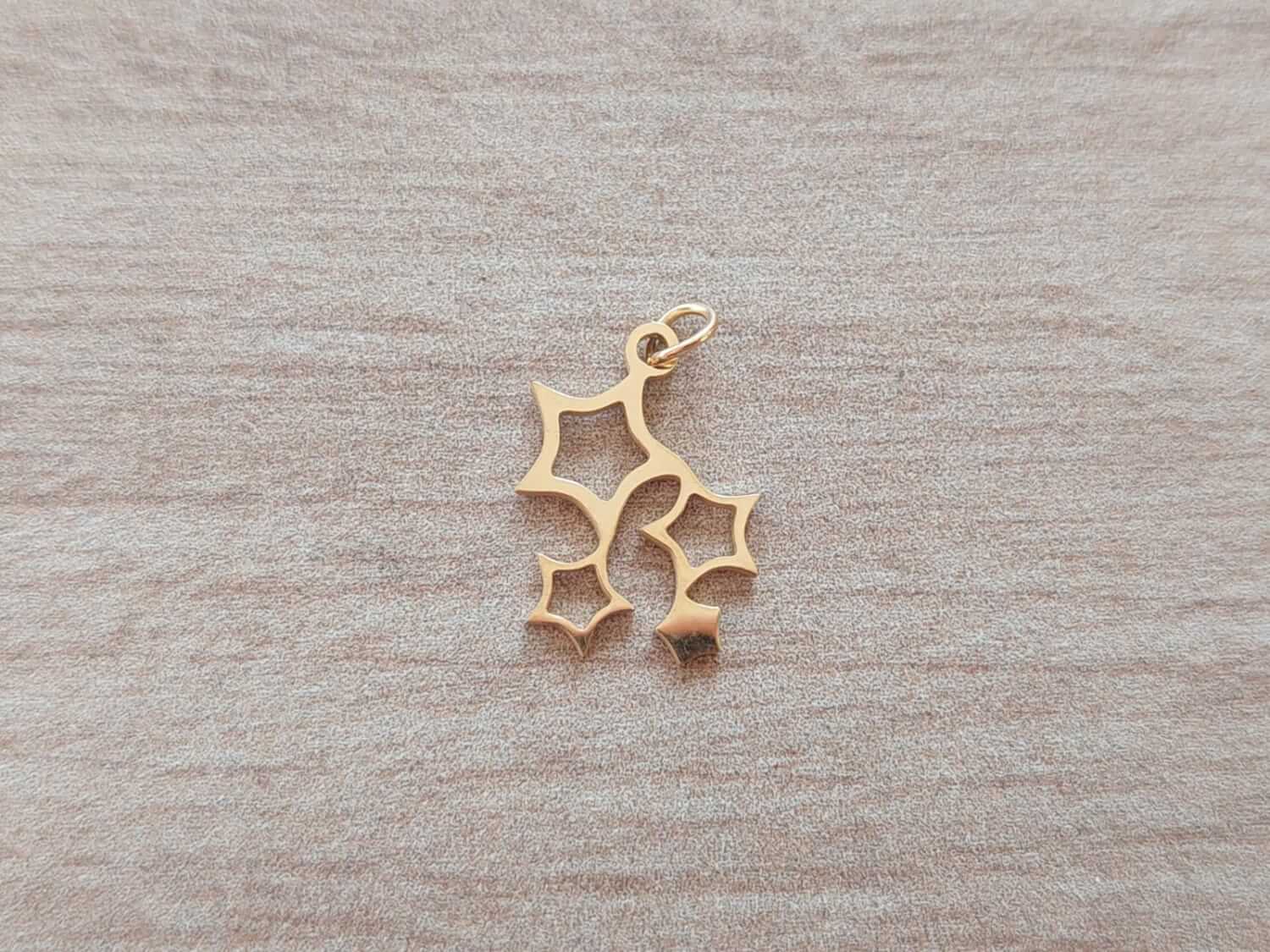DIJE DE ACERO DORADO 4 ESTRELLAS 17 X 13 MM