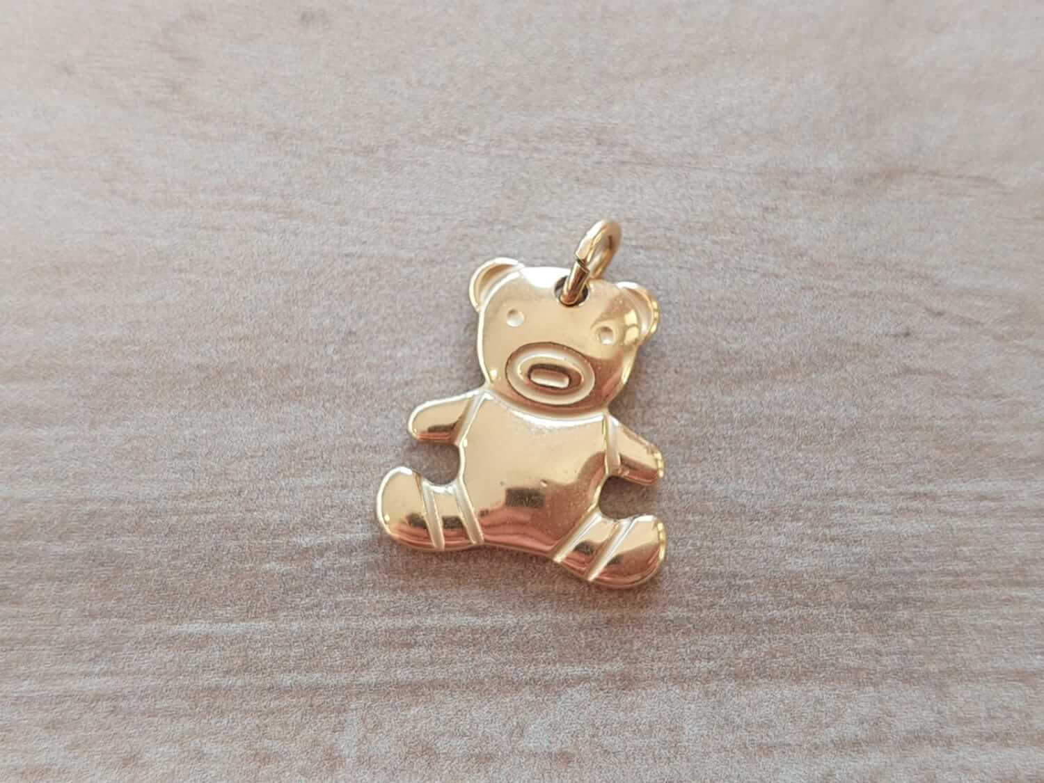 DIJE DE ACERO DORADO SILUETA OSITO EN RELIEVE. MEDIDAS APROX 20 MM .