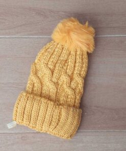 GORRO TEJIDO CON PIEL EN SU INTERIOR COLOR AMARILLO CON POMPÓN DE PIEL.