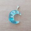DIJE DE ACERO LUNA ACRÍLICO NUBE CELESTE. BRILLA EN LA OSCURIDAD. MEDIDA 20 X 24  MM