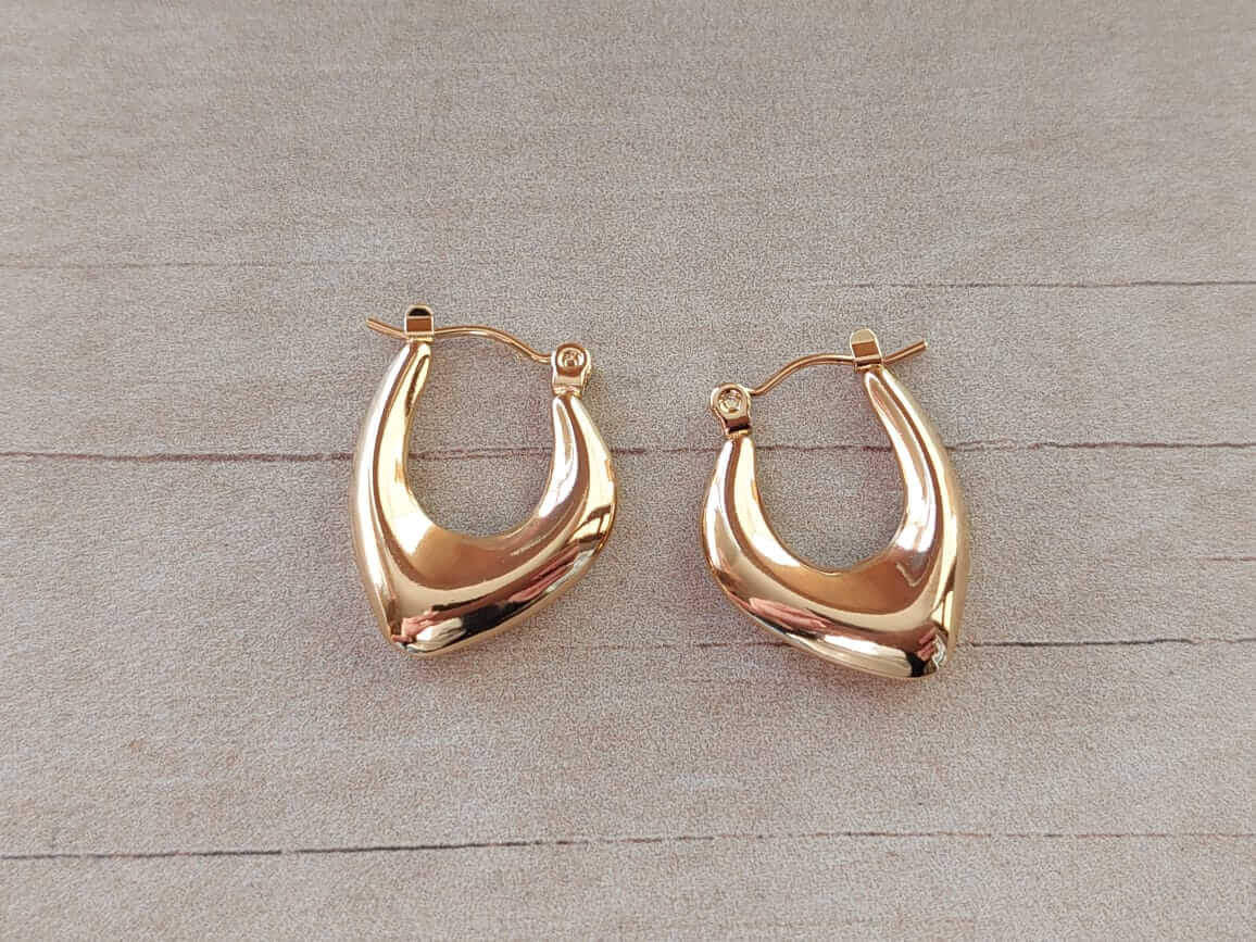 ARO DE ACERO DORADO ARGOLLA HUECA OVAL IRREGULAR. TAMAÑO 17 X 23 MM