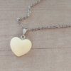COLGANTE CADENA DE ACERO ESPEJITO CON DIJE CORAZÓN RESINADO AMARILLO TAMAÑO 20 X 15 MM. LARGO 45 CM