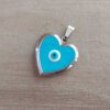 DIJE DE ACERO RELICARIO CORAZÓN ESMALTADO COLOR CELESTE CON OJITO TURCO EN EL CENTRO. TAMAÑO 22 MM