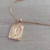 DIJE DE ACERO DORADO MEDALLA RECTANGULAR TRABAJADA EN RELIEVE CON INICIAL "V" Y CADENA ESPEJITO X 45 CM. TAMAÑO 15 X 20 MM