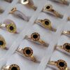 ANILLOS DE ACERO DORADO X 36 UNIDADES ESTILO SIN FIN CON CIRCULO DE 8 MM GRABADO Y ESMALTADO EN NEGRO. (MEDIDAS DEL 16 AL 20)