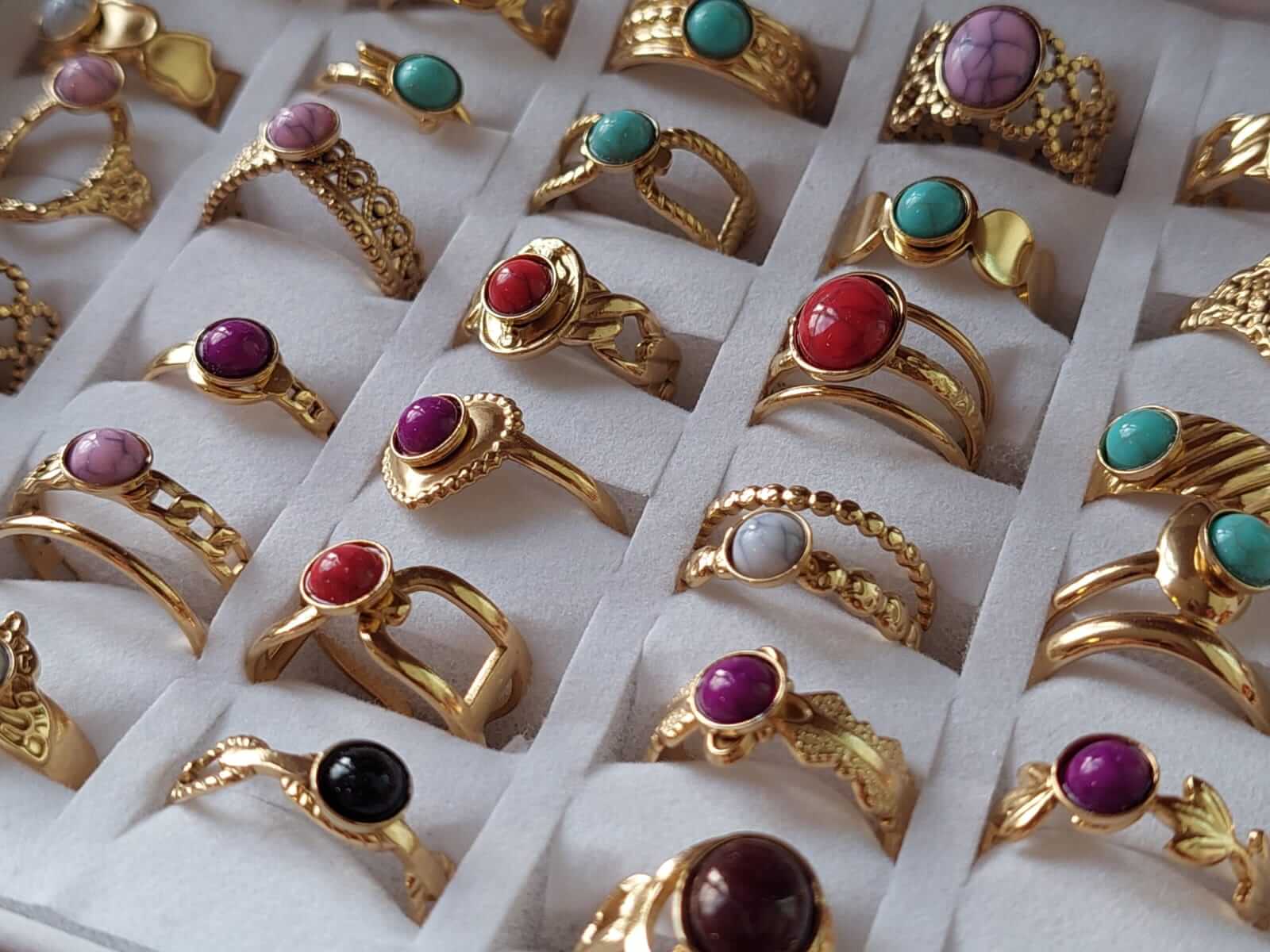 ANILLOS DE ACERO DORADO CON RESINA COLOR SÍMIL PIEDRA MIX X 36 UNIDADES, REGULABLE (MEDIDA ÚNICA)