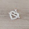 DIJE DE ACERO BLANCO CORAZÓN CON STRASS ALREDEDOR Y FLECHA CON LEYENDA MAMA. TAMAÑO 15 X 21 MM.