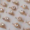 ANILLOS DE ACERO DORADO STRASS CUADRADO PEGADO 8MM SOBRE CINTA CON TRES STRASS A CADA LADO X 36 UNIDADES. (MEDIDAS DEL 16 AL 20)