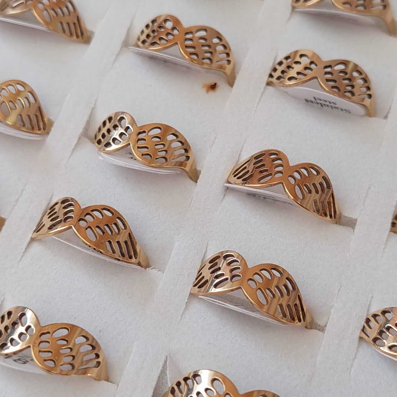 ANILLOS DE ACERO DORADO FIGURA CALADA (ALAS) X 36 UNIDADES. (MEDIDAS DEL 17 AL 22)