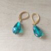 ARO DE ACERO DORADO BRISURA CON LAGRIMA VERDE ESMERALDA. LARGO TOTAL 32 MM.