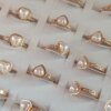ANILLOS DE ACERO DORADO X 36 UNIDADES CON CORAZÓN DE PERLA Y STRASS. (MEDIDAS DEL 16 AL 20)