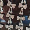 BLISTER DE AROS PASANTE DE ACERO MOÑO CON STRASS Y STRASS COLGANTES. X 12 PARES.