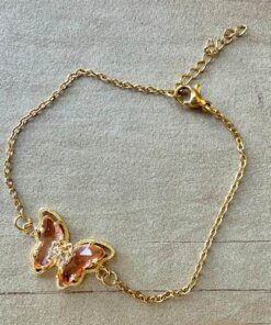 PULSERA DE ACERO DORADO ESLABÓN ESPEJITO CON MARIPOSA C/ STRASS Y ACRÍLICO CHAMPAGNE EN EL CENTRO. LARGO 17,5 + 2,5 CM EXT