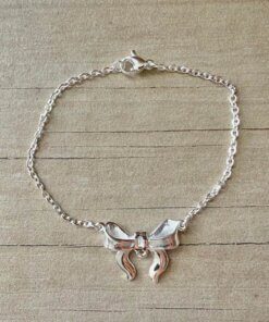 PULSERA DE ACERO BLANCO ESLABÓN ESPEJITO CON DIJE MOÑO EN EL CENTRO. LARGO 18 CM