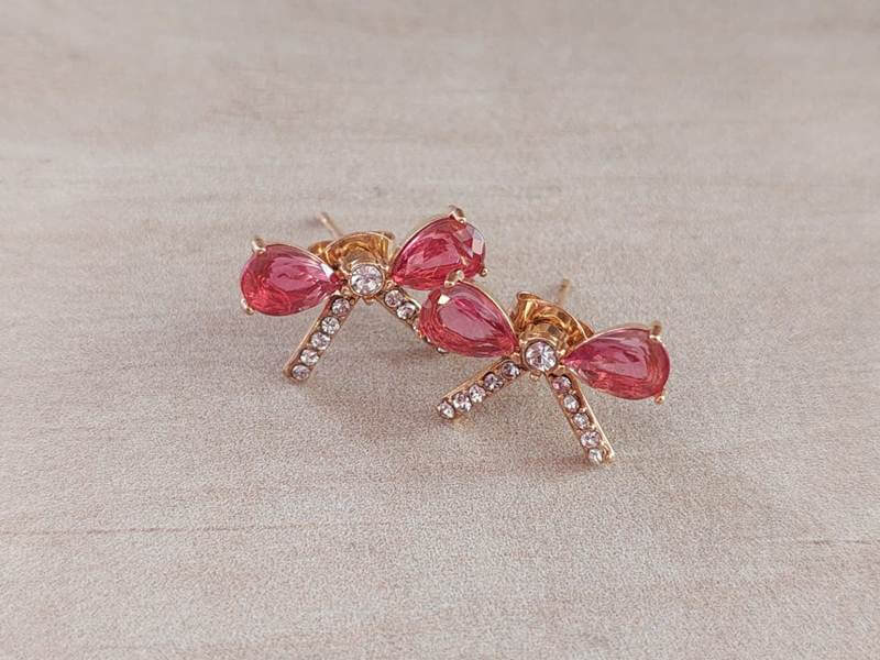 ARO DE ACERO DORADO MOÑO CON STRASS Y CUBIK FUCSIA. MEDIDAS 18 X 11 MM