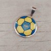 DIJE DE ACERO PELOTA FÚTBOL PLANA CON GAJOS ESMALTADOS AZUL Y AMARILLO. DIÁMETRO 25 MM