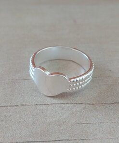 ANILLO DE ACERO BLANCO CINTA LABRADO CON CORAZÓN CENTRAL.