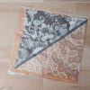 PAÑUELO RASADO ESTAMPADO ARABESCOS Y GARABATOS CON FONDO MARRÓN Y NEGRO, BORDE SUELA. TAMAÑO 70 X 70