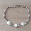 PULSERA DE ACERO DE BOLITAS 3 MM CON TRES BOLITAS DE NÁCAR IRREGULARES EN EL CENTRO. LARGO 18 CM.