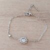 PULSERA DE ACERO ESPEJITO CON CENTRO STRASS OVALADO CON STRASS ALREDEDOR Y SUSANITO. LARGO 15,5 CM + EST. DE 4 CM