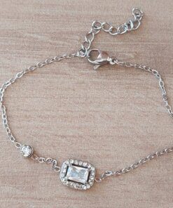 PULSERA DE ACERO ESPEJITO CON CENTRO STRASS RECTANGULAR CON STRASS ALREDEDOR Y SUSANITO. LARGO 15,5 CM + EST. DE 4 CM