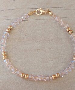 PULSERA DE TANZA CON MOSTACILLAS ROSAS, DOS BOLITAS 3 MM INTERCALADAS Y TERMINAL DE ACERO DORADO. LARGO 18,5 CM.