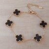 PULSERA DE ACERO DORADO ESLABÓN ESPEJITO CON DIJE VAN CLEEF ACRÍLICO NEGRO. LARGO 17,5 + 6 CM EXT.