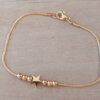 PULSERA DE ACERO DORADO ESLABÓN COLA DE RATÓN CON BOLITAS DE 3 MM Y ESTRELLA CENTRAL. LARGO 18,5 CM