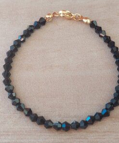 PULSERA DE TANZA CON MOSTACILLAS NEGRAS Y TERMINAL DE ACERO DORADO. LARGO 18 CM.