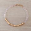PULSERA DE TANZA CON MOSTACILLAS ROSA, BOLITAS 3 MM CENTRALES Y TERMINAL DE ACERO DORADO. LARGO 18 CM.