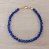 PULSERA DE TANZA CON MOSTACILLAS AZULES Y TERMINAL DE ACERO DORADO. LARGO 18 CM.