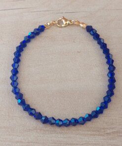 PULSERA DE TANZA CON MOSTACILLAS AZULES Y TERMINAL DE ACERO DORADO. LARGO 18 CM.