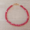 PULSERA DE TANZA CON MOSTACILLAS ROJAS Y TERMINAL DE ACERO DORADO. LARGO 18 CM.