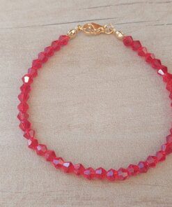 PULSERA DE TANZA CON MOSTACILLAS ROJAS Y TERMINAL DE ACERO DORADO. LARGO 18 CM.