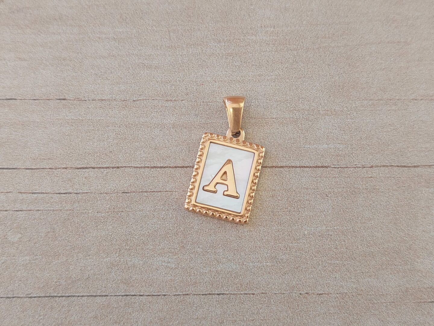 DIJE DE ACERO DORADO INICIAL. TAMAÑO 12 X 15 MM
