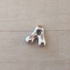 DIJE DE ACERO INICIAL. TAMAÑO APROXIMADO 10 X 15 MM
