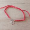 PULSERA DE HILO ROJO AJUSTABLE CON BOLITAS Y DIJE DE ACERO ESTRELLA CON STRASS.