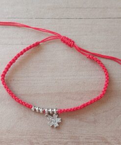 PULSERA DE HILO ROJO AJUSTABLE CON BOLITAS Y DIJE DE ACERO FLOR CON STRASS.
