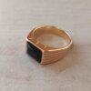 ANILLO DE ACERO DORADO CON SÍMIL PIEDRA NEGRA