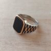 ANILLO DE ACERO COMBINADO CON DORADO Y SÍMIL PIEDRA NEGRA