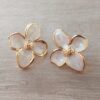 ARO DE ACERO DORADO PASANTE FLOR BOMBE EFECTO RELIEVE ESMALTADA EN BLANCO. TAMAÑO 25 X 30 MM.