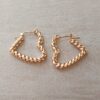 ARO DE ACERO DORADO ARGOLLA HUECA CON FORMA DE CORAZÓN RETORCIDO. TAMAÑO 23 X 22 MM