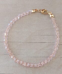 PULSERA DE TANZA CON MOSTACILLAS ROSA Y TERMINAL DE ACERO DORADO. LARGO 18 CM.