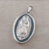 DIJE DE ACERO MEDALLA OVALADA VIRGEN DE GUADALUPE ESMALTADA EN NEGRO. TAMAÑO 28 X 40 MM.