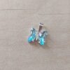 DIJE DE ACERO BLANCO MARIPOSA ACRÍLICO CELESTE. MEDIDA 10 X 11 MM