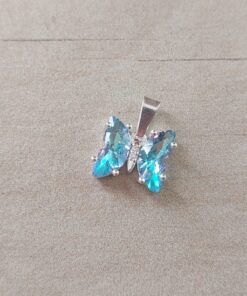 DIJE DE ACERO BLANCO MARIPOSA ACRÍLICO CELESTE. MEDIDA 10 X 11 MM