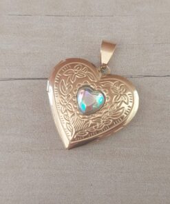 DIJE DE ACERO DORADO RELICARIO CORAZÓN TRABAJADO CON ACRÍLICO TORNASOL EN EL CENTRO. TAMAÑO 28 MM